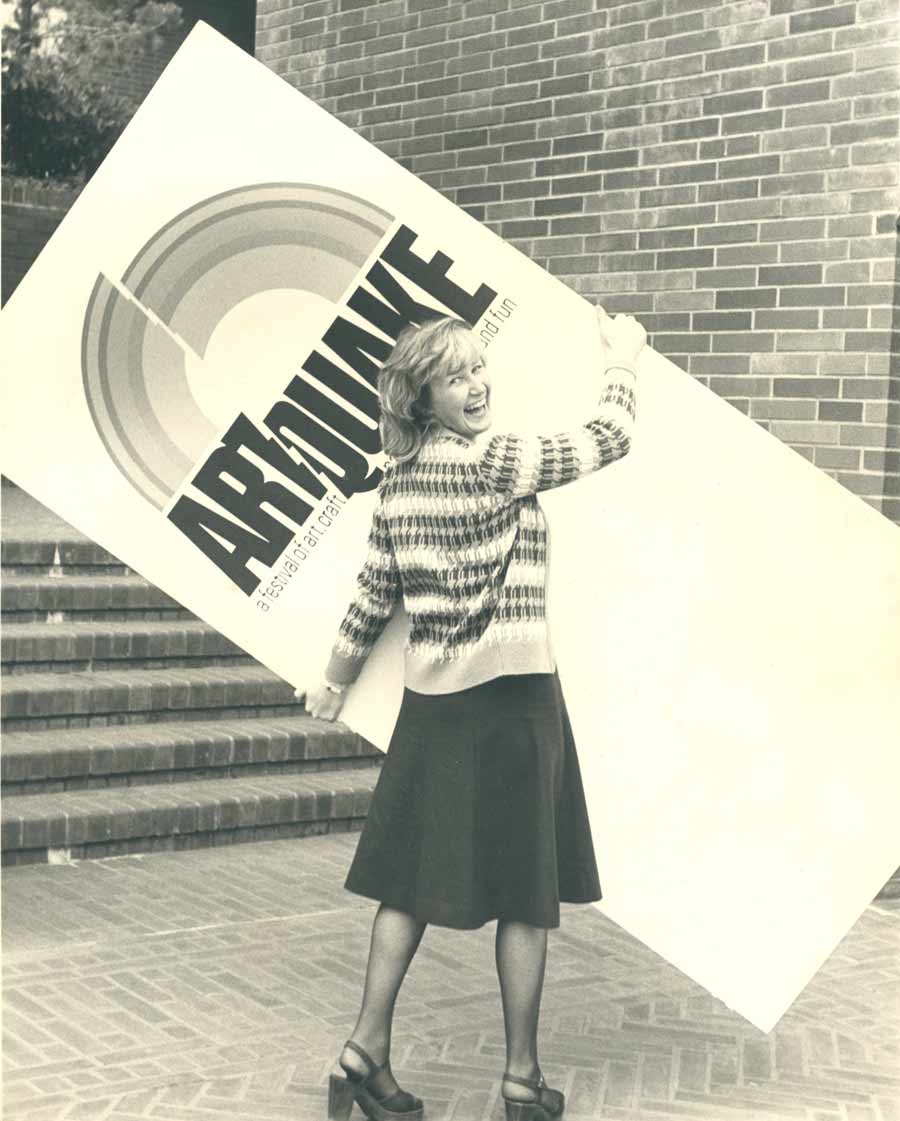 A woman looking back with a smiling face while holding a banner