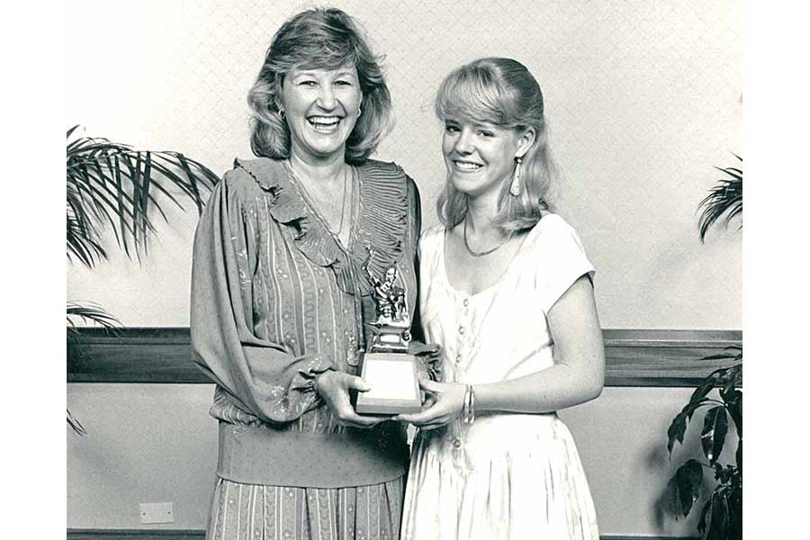 Ladies smiling while holding a trophies