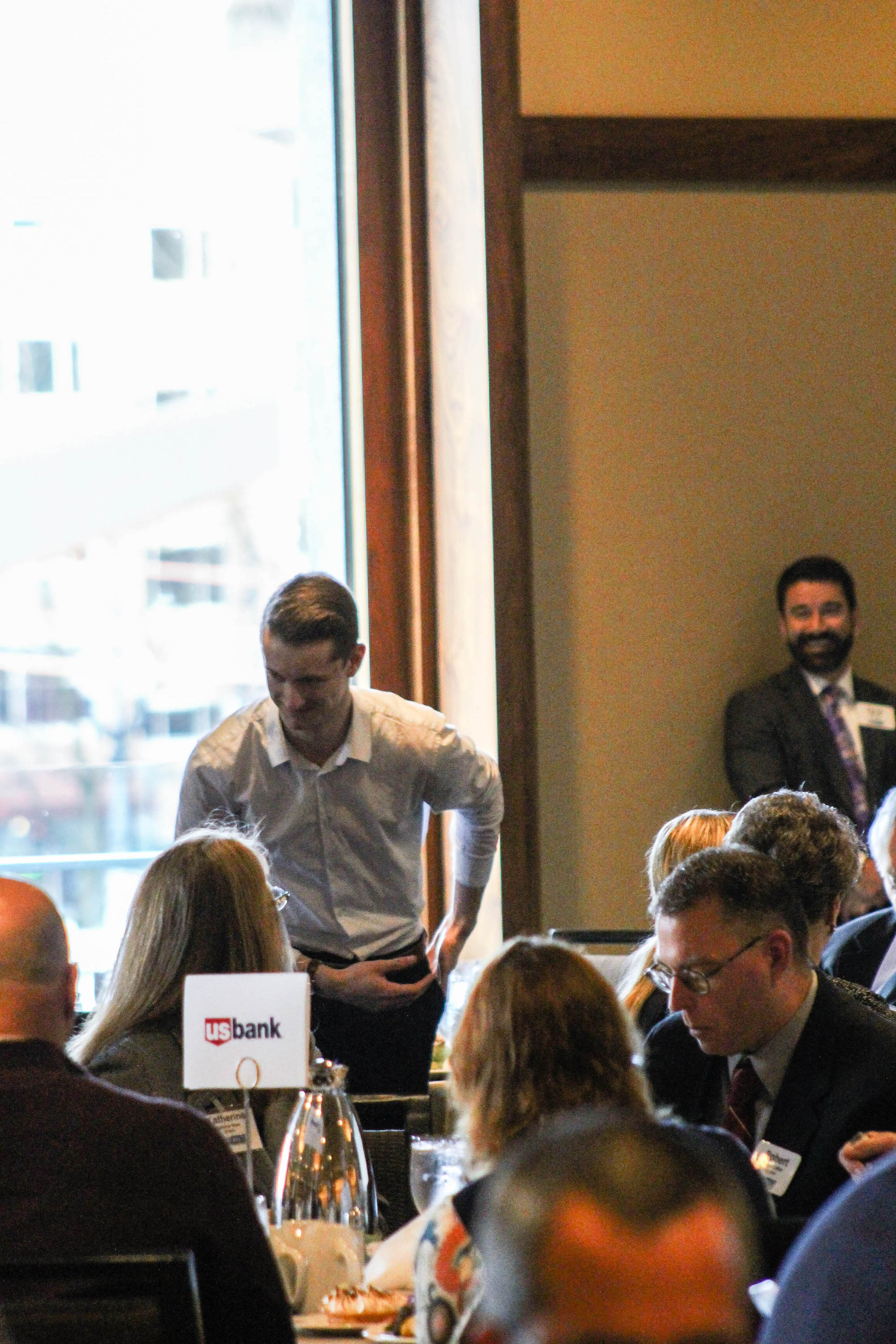 man bowing down infront of people in a conference room