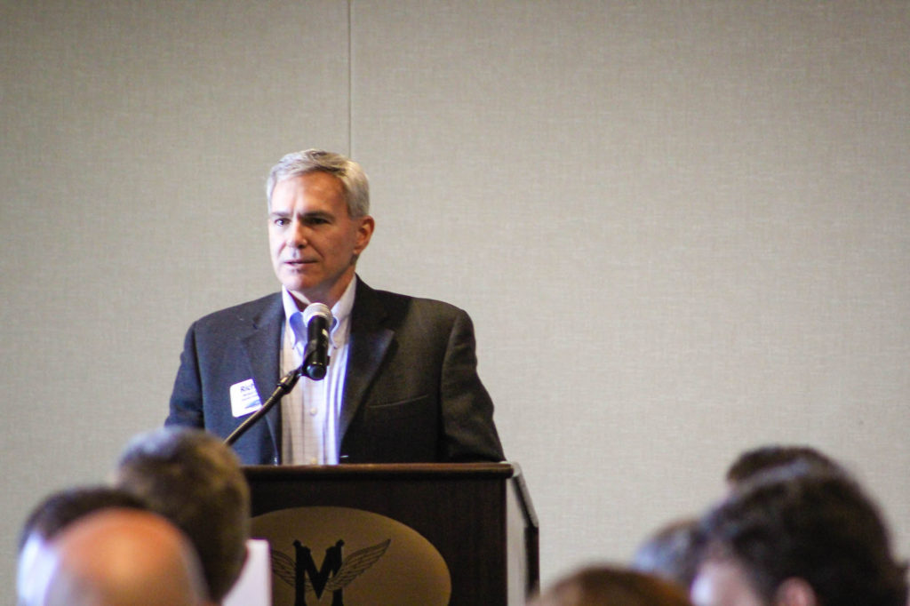 Man standing behind rostrum doing conference