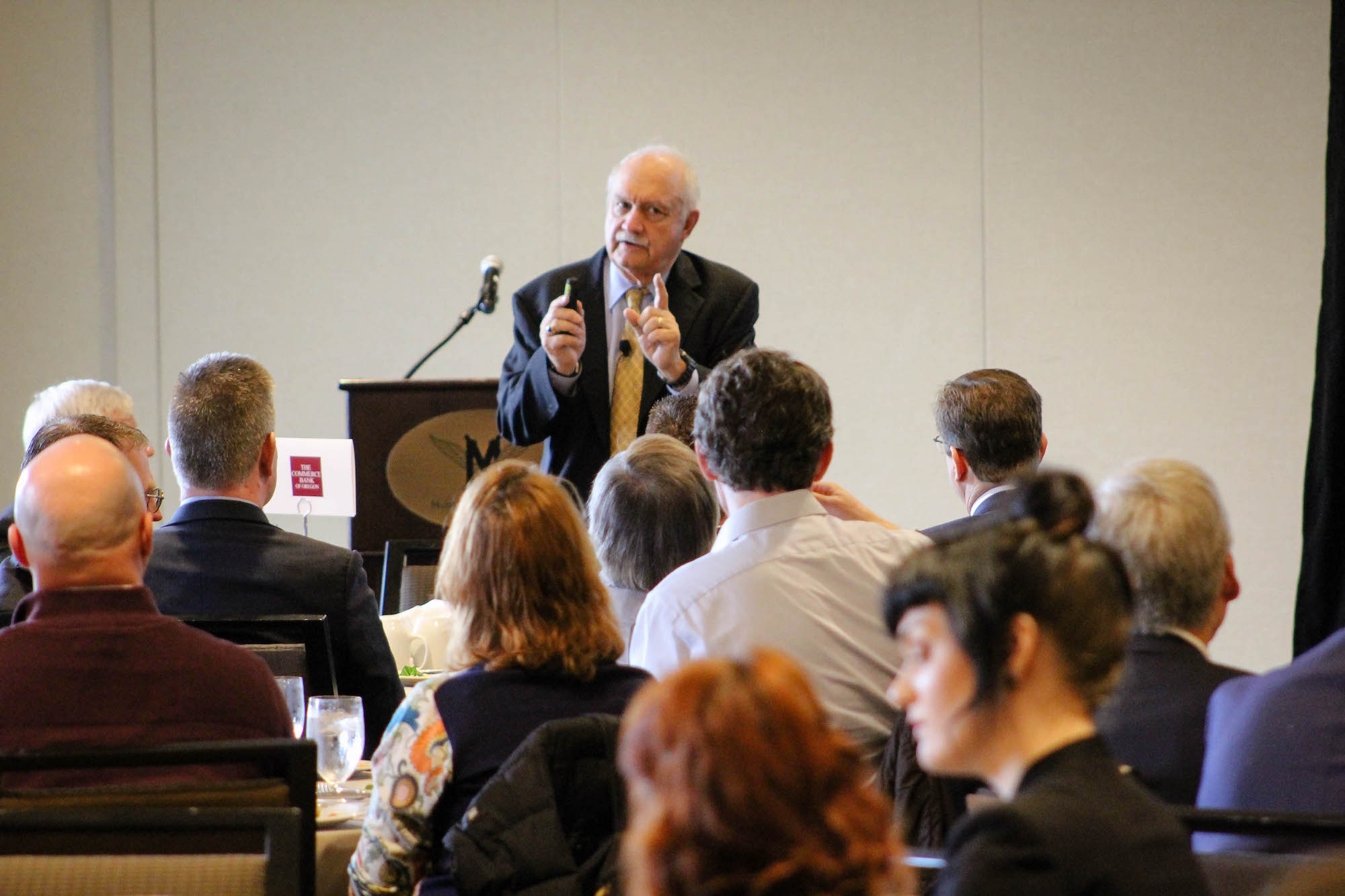 Old man presenting to the people in a room