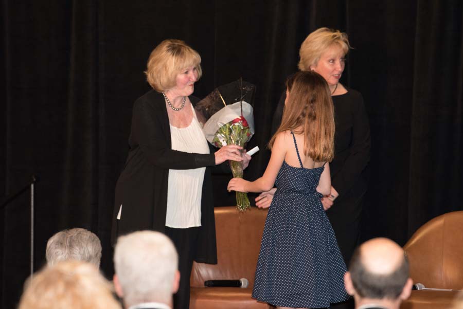 Girl presenting a bouquet to an old lady