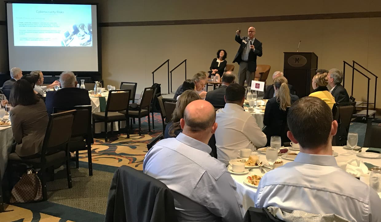 Man pointing at listeners while presenting slides on projector